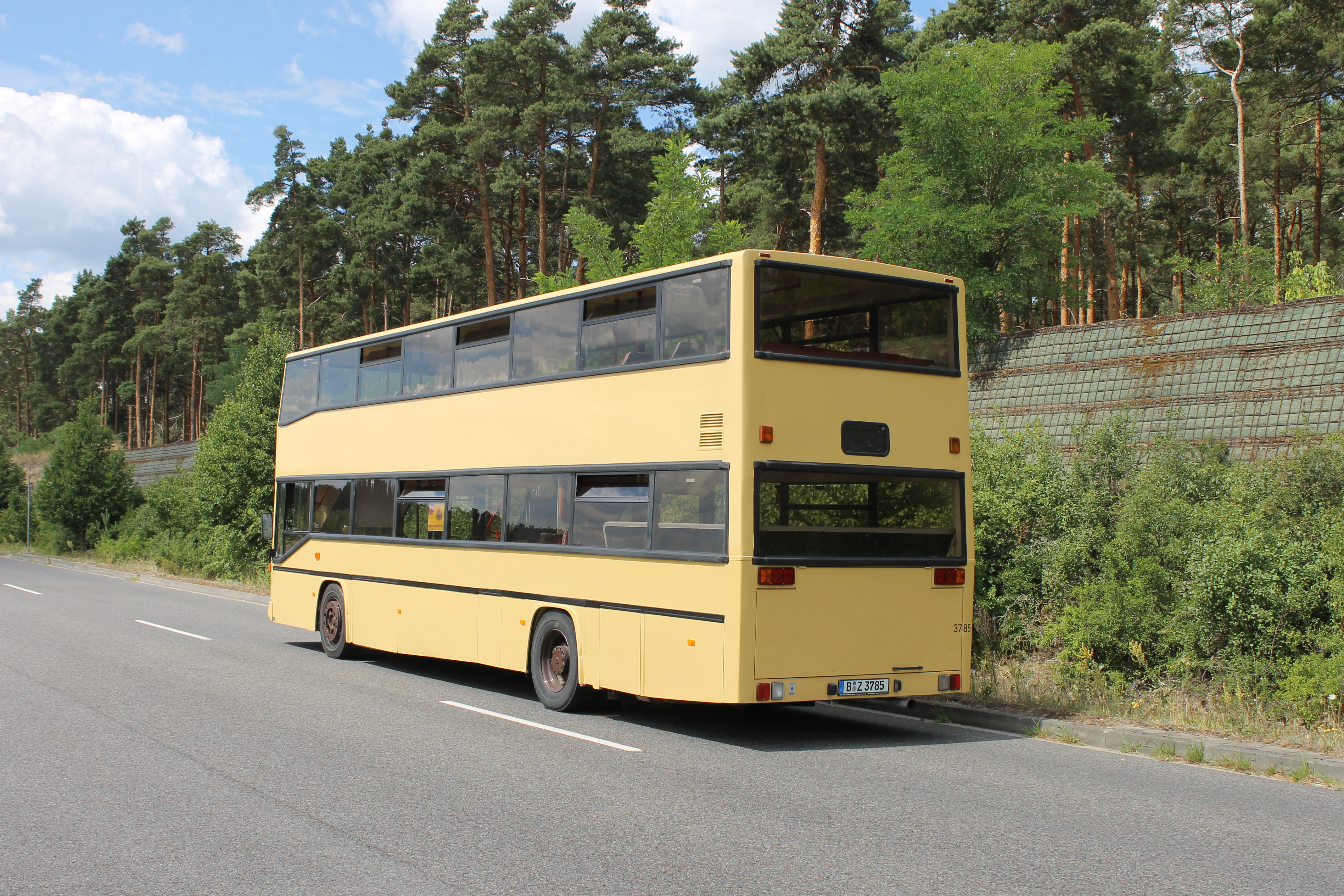 Historischer gelber MAN-Doppeldeckerbus (B-Z 3785) von hinten am Straßenrand