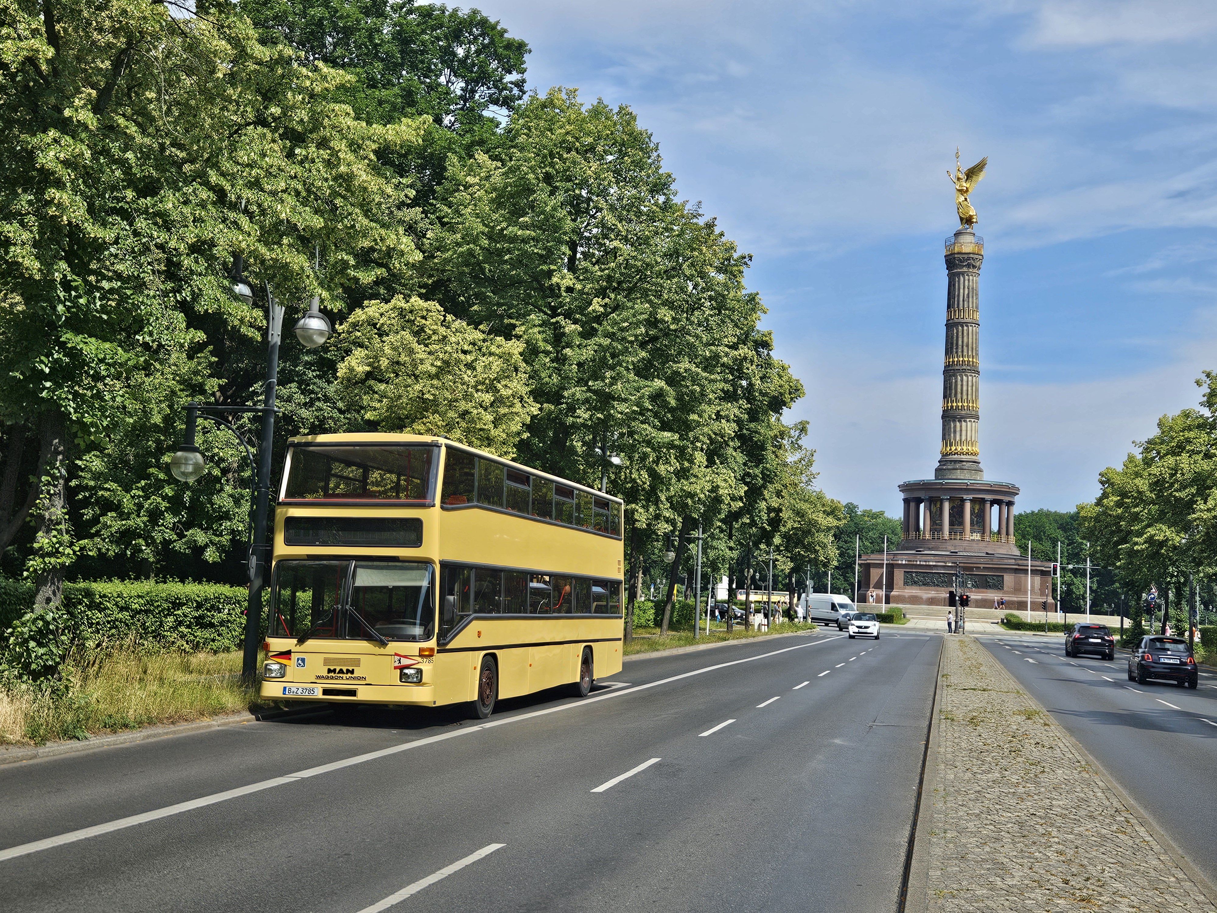 Der historische gelbe Doppeldeckerbus unterwegs an der Berliner Siegessäule
